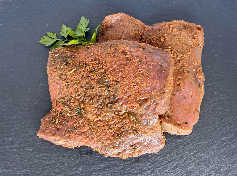 Marinierte Steaks mit Kräuterpanade und Petersilie auf einer Schieferplatte